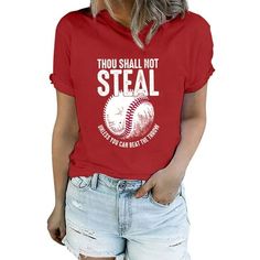 a woman wearing a red t - shirt that says thou shall not steal and has a baseball