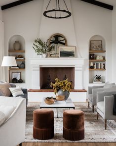 a living room filled with furniture and a fire place in the middle of a room