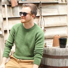 a man sitting on top of a wooden barrel