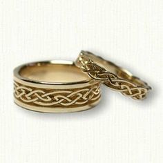 two gold wedding rings sitting next to each other