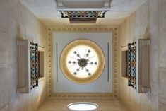 a large clock mounted to the side of a wall in a room with white walls