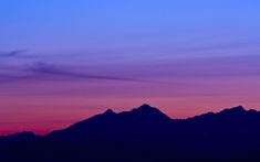 a purple and blue sky with mountains in the background