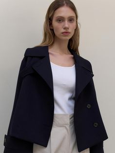 This is a clean and casual trench jacket by L’oiE that is made out of high quality and sturdy fabric. With unique design detail and trendy mood, you can style it for your refined and casual daily outfit.- Unique short length- Vent detail on the back and button detail- Modern and sophisticated look Chic Navy Outerwear With Lapel Collar, Navy Lapel Collar Outerwear For Office, Navy Collared Outerwear For Work, Navy Outerwear With Lapel Collar For Work, Navy Oversized Outerwear For Work, Oversized Navy Outerwear For Work, Chic Navy Outerwear For Business Casual, Chic Navy Outerwear For Fall, Chic Peacoat With Lapel Collar