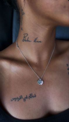 a woman with tattoos on her chest wearing a black shirt