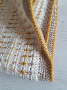 a crocheted blanket laying on top of a wooden table