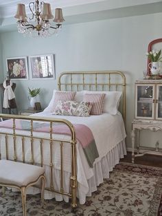 a bedroom with a bed, dresser and chandelier