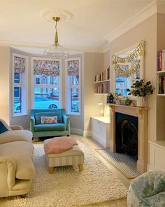 a living room filled with furniture and a fire place in front of a window next to a fireplace