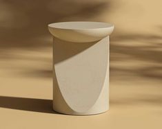 a white vase sitting on top of a table