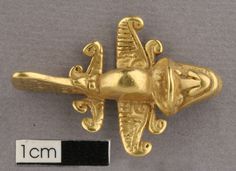 a gold brooch with an ornate design on it