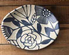 a blue and white plate sitting on top of a wooden table next to a wall