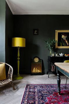 a living room filled with furniture and a large painting on the wall next to a table