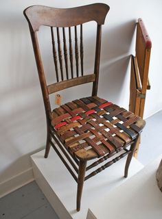 a wooden chair sitting on top of a white pedestal