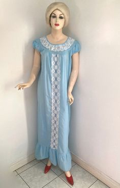 "Vintage 1960s/1970's ADORABLE NIGHTGOWN by SLUMBER SUZY DREAMWEAR in size MEDIUM.  Made in CANADA of 65% polyester and 35% cotton (exclusive of trimming), it is blue with white lace trims and a darker blue ribbon woven down through the lace down the front.  It has capped short sleeves and a ruffled bottom and is in excellent wearable vintage condition. Laying flat it measures: 16\" from shoulder to shoulder 3.5\" from shoulder to cuff  21\" across the bust  23\" across the waist 23.5\" across t Vintage Dresses For Pajama Party, Vintage Sleepwear For Hospital Use, Vintage Nightgown For Sleepovers, Retro Nightgown For Sleepovers, Retro Summer Nightgown For Sleep, Vintage Blue Cotton Nightgown, Blue Vintage Cotton Nightgown, Vintage Blue Sleepwear, Vintage Blue Nightgown For Home