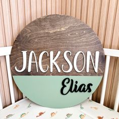 a wooden sign that says jackson and the name elias on it sitting on top of a white chair