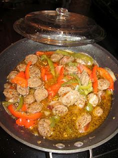 a pan filled with meat and vegetables cooking on top of a stovetop burner