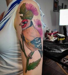 a woman with a bird and flower tattoo on her arm