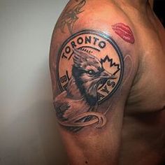 a man with a tattoo on his arm that has an eagle and the words toronto