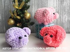 two crocheted stuffed animals sitting next to a christmas tree