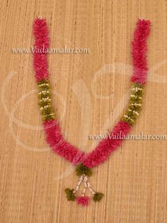 the necklace is adorned with pink and green beads