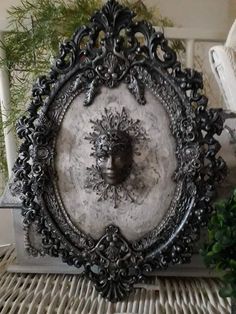 an ornate metal bowl sitting on top of a table next to a potted plant