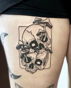 a woman's thigh with a skull tattoo on it