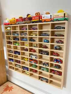 a wooden shelf filled with lots of toy cars