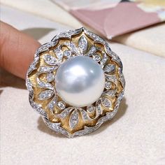 This royal style ring using Italy Buccellati process. Product Information OriginSouth Sea Pearl Jewelry Processed in Japan MaterialSouth Sea Pearl, 18k Gold and Natural Diamond DimensionsTop Approx. 3.0 x 2.7 cm Pearl Shaped: Round Size: 14 mm Quality: AAAA Nacre: Very Thick Color: White Luster: Very High Accessories Metal: 10.5g of 18k Gold and White Gold Other: 0.85ct of Natural Diamond Luxury Dome Ring With 17 Jewels, Luxury White Diamond Dome Ring, Luxury Diamond White Dome Ring, Luxury White Gold Dome Ring With Gemstone, Luxury Yellow Gold Pearl Ring With Polished Finish, Luxury Pearl Ring With Round Cut, Luxury White Gold Pearl Ring, Luxury Gold Pearl Ring, Luxury Diamond White Pearl Ring