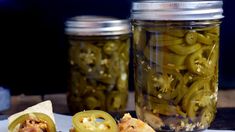 pickles and tortilla chips sit on a table next to jars of pickles