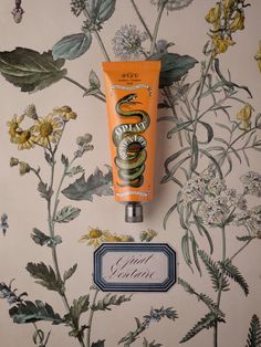 a tube of sunscreen sitting on top of a wall next to a sign and flowers