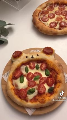 two small pizzas with toppings on wooden plates