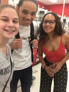 two girls and a man standing in a store