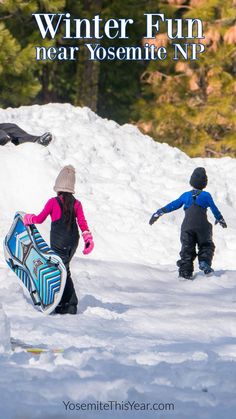 two children are playing in the snow with their snowboards and skis while another child is walking behind them