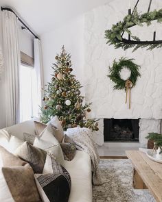 a living room filled with furniture and a christmas tree in front of a fire place