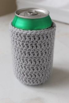 a crocheted can holder with a green top