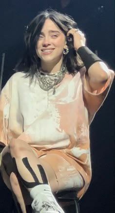 a woman sitting on top of a chair next to a microphone