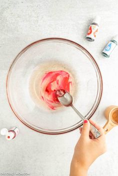 someone is mixing something in a bowl with a spoon and some other items around it