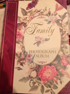 a book with flowers on it sitting on top of a table next to other books