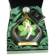 a bottle in a box with a green ribbon around it