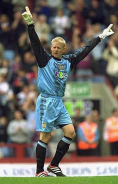 a soccer player is holding his arms up in the air with one hand and two fingers raised