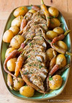 a green plate topped with meat, potatoes and carrots