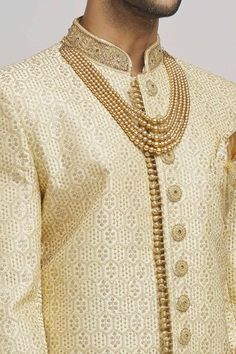 Ivory and golden sherwani with floral frame embroidery. Paired with an inner kurta and churidar. - Aza Fashions Gold Traditional Wear With Naqshi Drape, Festive Gold Sherwani With Naqshi Detailing, Festive Gold Sherwani With Naqshi, Ceremonial Gold Kurta With Naqshi Details, Ceremonial Gold Kurta With Naqshi, Festive Gold Kurta With Naqshi Detail, Gold Sherwani With Dupatta For Transitional Season, Festive Sherwani With Gold Embroidery For Festivals, Gold Sherwani With Dupatta For Festive Occasions