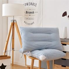 a blue and white checkered chair sitting in front of a lamp