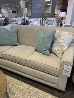 a couch with many pillows on it in a store