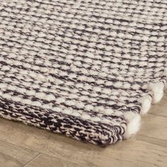 a close up of a rug on the floor with white and black colors in it