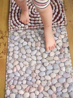 a child standing on a rug made out of rocks