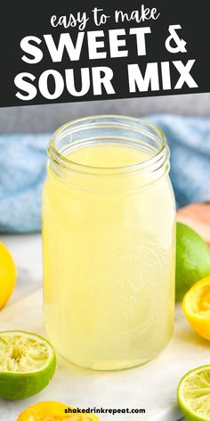 a mason jar filled with homemade sweet and sour mix next to sliced lemons on a table