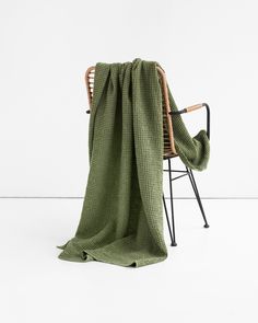 a green blanket sitting on top of a chair