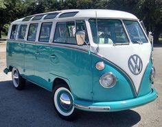 a blue and white vw bus parked in a parking lot