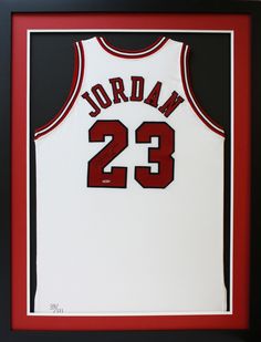 a framed jersey with the number 23 on it is displayed in a black and red frame