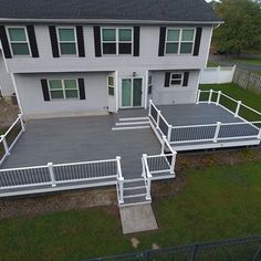 an aerial view of a two story house with white railings and steps leading to the front door